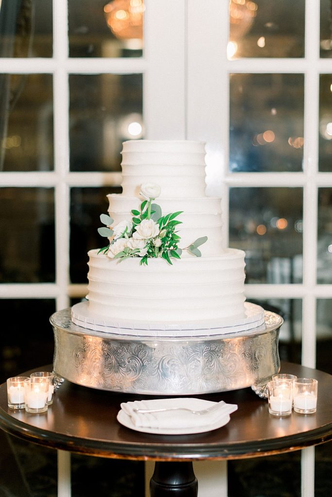 elegant white cake with floral arrangement